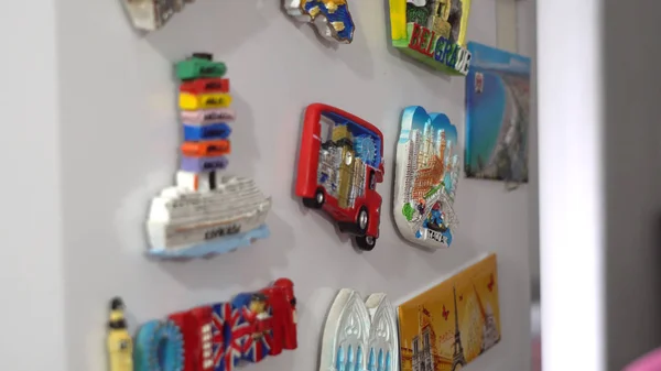 Adding a new fridge magnets from the last vacation, travel concept, cinematic dof