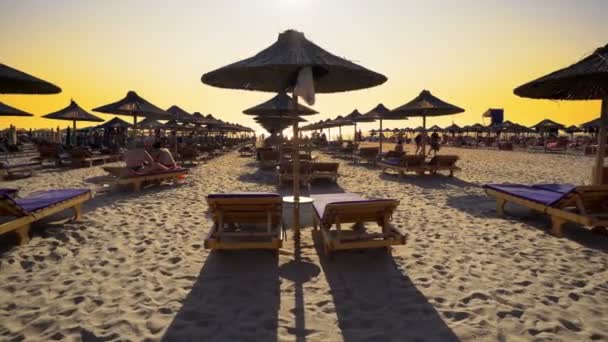Günbatımında Saman Şemsiyeli Lüks Yaz Plaj Beldesi Sinematik Steadicam Çekim — Stok video