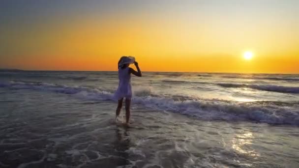 Kvinna Med Hatt Stänkte Vågor Stranden Sunset — Stockvideo