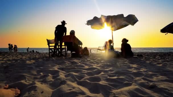 Силуэты Пожилых Людей Наслаждаются Здоровым Отдыхом Пляже Зонтиком Закате Кинематограф — стоковое видео