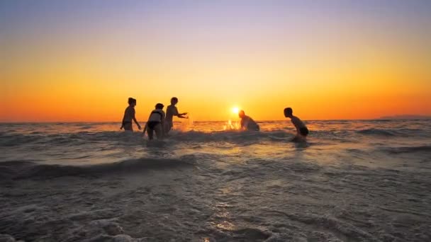 Grupo Personas Felices Jugando Rociando Agua Playa Atardecer Belleza Alegres — Vídeos de Stock