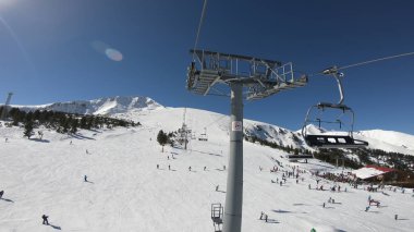 Ski lift üzerinde insanlar kayak ve snowboard manzaralı dağ yamacında gidiş sandalyeyle