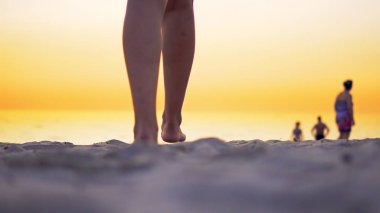 Genç Latin Amerikalı kız okyanus plaj tarafından günbatımında yürüyüş çıplak bacaklar ayak