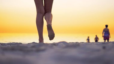 Genç Latin Amerikalı kız okyanus plaj tarafından günbatımında yürüyüş çıplak bacaklar ayak