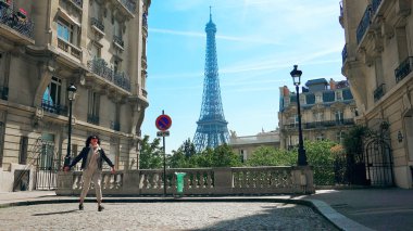 Model kadın Paris, Fransa 'da Camoens Caddesi' nde yürüyen Eyfel Kulesi 'nin keyfini çıkar.