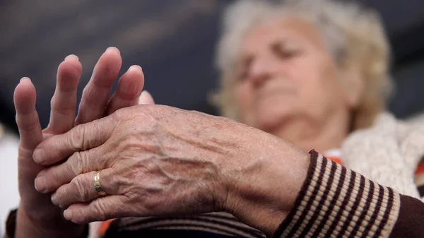 Senior Mulher Tocando Sua Mão Ferida Sentado Baloiço Alpendre Sofrendo — Fotografia de Stock