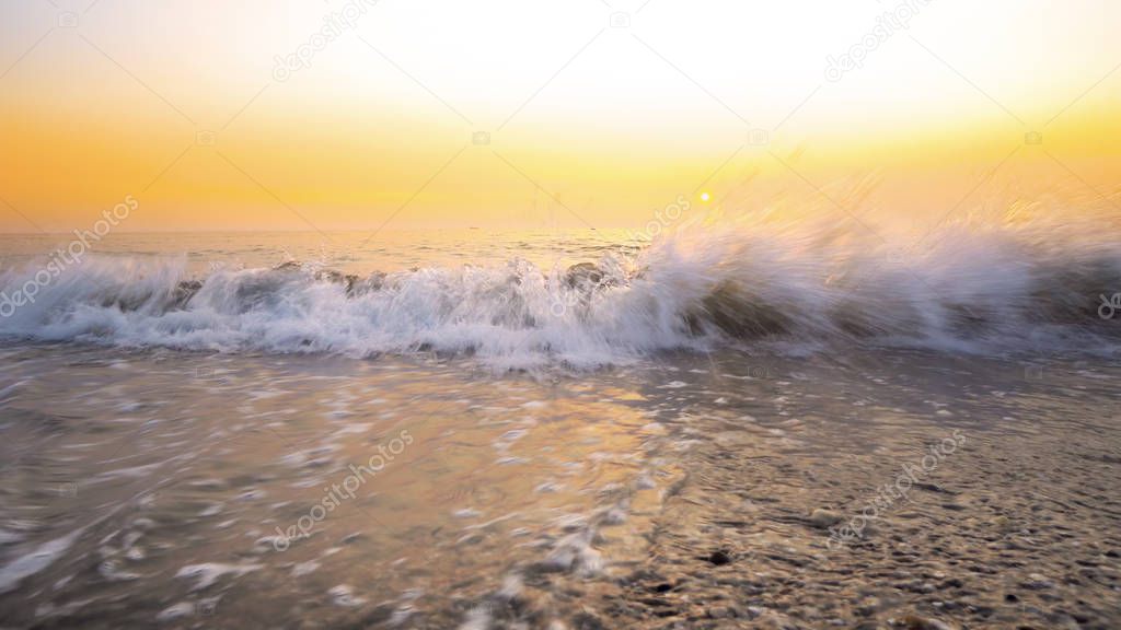 Amazing background from sea waves splashing beach sand at sunset