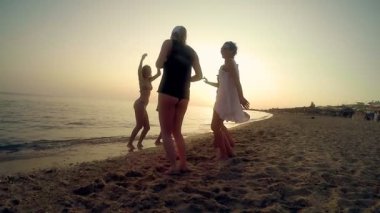 Güneşli gün, ağır çekim kumsalda dans kızlar