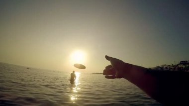 İle Frisbee kumsalda gün batımında, ağır çekim Pov oynayanlar