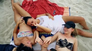 Bir daire içinde bir kum plajındaki yalan ve having fun gençler gülümseyen