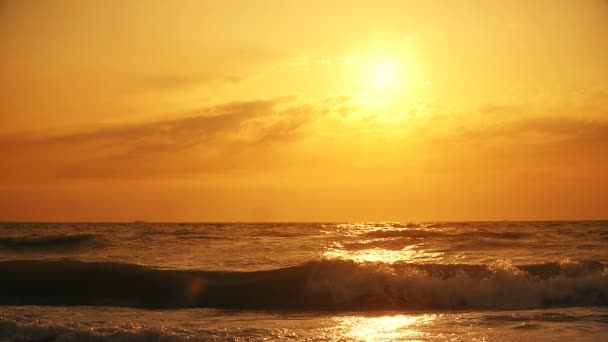ビーチでの夕日 海の上に黄金の夕日の静かな牧歌的なシーンは 波がゆっくりと砂の上に水しぶき — ストック動画