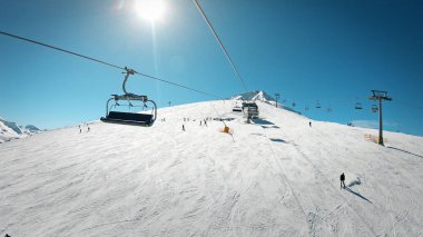 Ski lift üzerinde insanlar kayak ve snowboard manzaralı dağ yamacında gidiş sandalyeyle