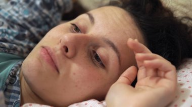 Uyku zamanı eğlenceli. Genç gülümseyen genç uykulu kız kardeşi alay yatakta eğleniyor