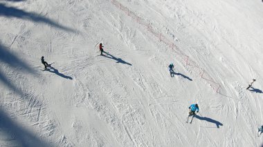 Kayak merkezi, yamaç, kayak asansöründeki insanlar, yüksek irtifadaki dağ zirvesindeki kayakçılar.