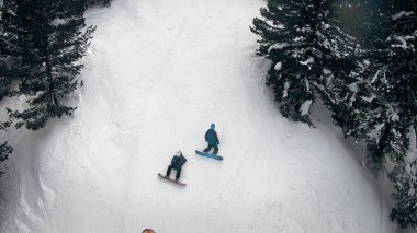 Yaralı snowboard ve kar arabası ilkyardım motor kızak orman çam ağaçları arasında bedava yolculuk dağ yamacında sürüş havadan görünümü