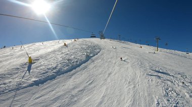 Güneşli bir günde kayakçıların ve snowboardcuların hava manzarası
