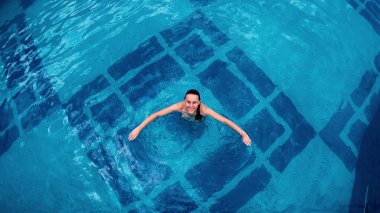 Hava - su kristal berraklığında havuz suyu içinde yatan tonda vücut olan güzel kadın