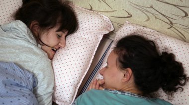 İki kız kardeş eğleniyor birlikte yatağa