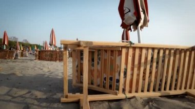 Boş Beach'te tatil beldesi katlanmış şezlong ve şemsiye ile gündoğumu gökyüzü arka plan üzerinde