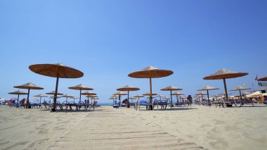 Şemsiye, şezlong üzerinde İyon Denizi ile boş Sunny Beach. İnsanların rahatlamak ve güneşlenmek sahil resort hattı