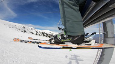 Neşeli arkadaş grubu üzerinde teleferik dağlarda kayak için kaldırma. Bacakları görüntülemek ve yamaç kayakçı ve Snowboard düşkünleri, yavaş hareket ile Kayak
