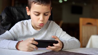 Smartphone üzerinde oynarken öfkeli küçük çocuk