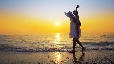 Aile eğleniyor plaj seyahat etmek tatil yaz tatili. Mutlu çocuk ve oynak neşeli piggybacking yaparken anne açık havada canlı günbatımında binmek