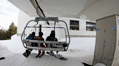 Bansko, Bulgaristan - Şubat, 2018 yaklaşık: Pov kayakçılar ve teleferik Bansko, Bulgaristan üzerinde kış döneminde yatılı Snowboard düşkünleri. Teleferik halklar yamaç, ağır çekim kadar kaldırdı