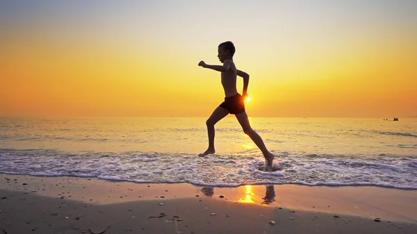 Fechar Menino Correndo Correndo Praia Mar Contra Pôr Sol — Fotografia de Stock