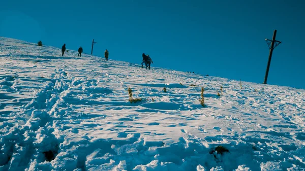 バンスコ 2018 晴れた日に大まかな雪で山の斜面を登るハイカー人のハンドヘルド ショット — ストック写真