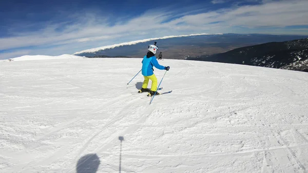 活跃的儿童与安全帽 护目镜和杆滑雪在斜坡上 — 图库照片
