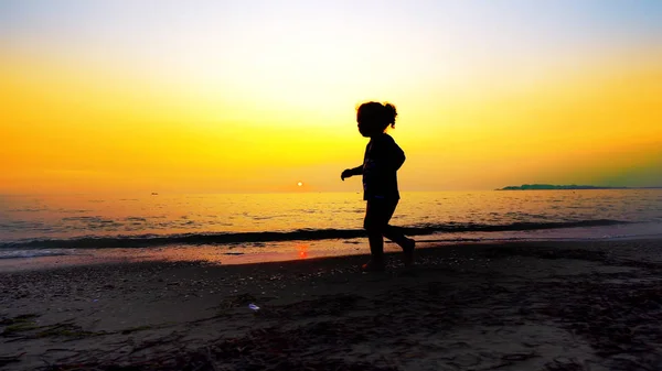 Силуэт Мальчика Идущего Пустому Пляжу Летним Закатом Заднем Плане — стоковое фото