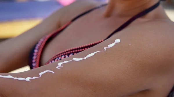 Modelo Feminino Aplicar Protetor Solar Creme Mão Ombro Sentado Praia — Fotografia de Stock