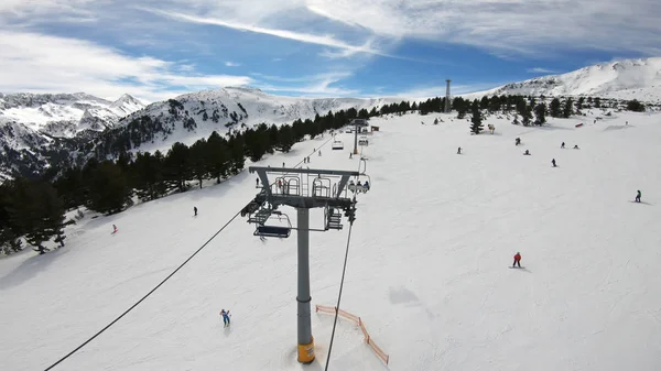 滑雪者和滑雪者在滑雪场下坡 在一个滑雪胜地 在晴朗的天空下 在晴朗的天空下 慢动作 滑雪场 在滑雪场上 有雪林 滑雪缆车和山 — 图库照片