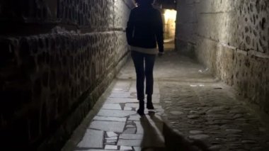 Bir kadın modeli karanlık sokakta geceleri, yürüyüş araştırıyorum dar kirli köşe, eski şehir sokak
