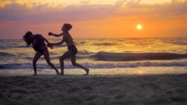 Karate sporu kızlar egzersiz, günbatımı, yavaş hareket karşı okyanus plaj üzerinde karate eğitimi