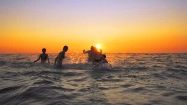Aile insan bir parti spraing yaşıyorsanız ve yaz üzerinde atlama plaj gün batımı, sinematik ağır çekim