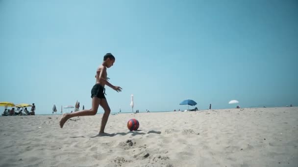 Sahilde Yavaş Futbol Oynayan Çocuk — Stok video
