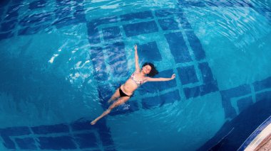 Büyük yüzme havuzunda su yüzeyinde yatan havadan görünümü