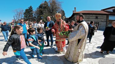 Bulgaristan 'ın Bansko kenti - 06 Nisan 2018: Bulgaristan' ın Bansko kentinde düzenlenen Paskalya geçit töreni. Rahipler ve insanlar geleneksel olarak sokaklarda yürürler, dini şarkılar söylerler ve çocuklara paskalya yumurtası verirler.