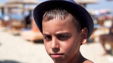 Kamera, sinematik dof gülümseyen plaj şapka ile mutlu İspanyol çocuk