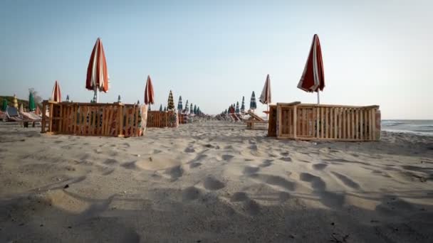Порожній Пляж Приморському Курорті Складеними Шезлонгами Парасольками Фоні Сходу Сонця — стокове відео