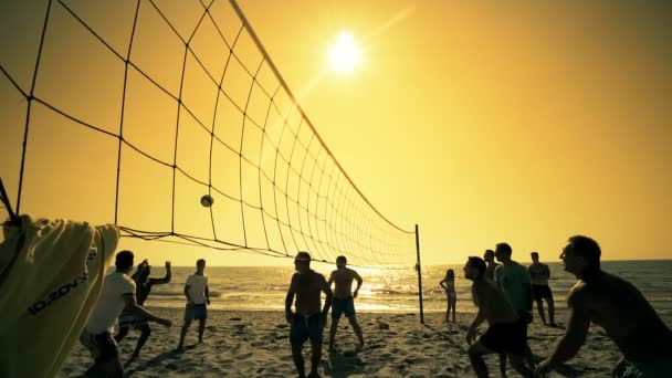 无法辨认的剪影人在日落时玩沙滩排球 慢动作 — 图库视频影像