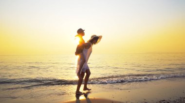 Aile eğleniyor plaj seyahat etmek tatil yaz tatili. Mutlu çocuk ve oynak neşeli piggybacking yaparken anne açık havada canlı günbatımında binmek