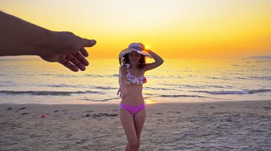 Romantik güzel kız sahilde birlikte yaz aylarında gülen adam, elini tutarak mayo ve şapka giriyor seyahat tatil tatil, tatil veya Sevgililer kavramı tatil