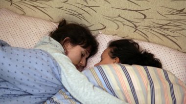 Eğleniyor iki genç kız yatak odasında mücadele. Rahibeler birlikte yatağa sarılma rahatlatıcı