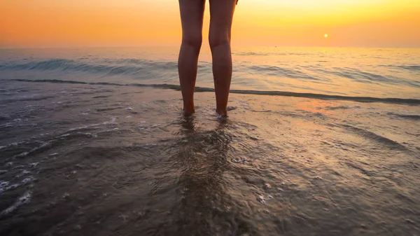 海滩夕阳西下 女人的脚被海浪拍打着 平静悠闲的大海洒落在美丽的海滩上 — 图库照片