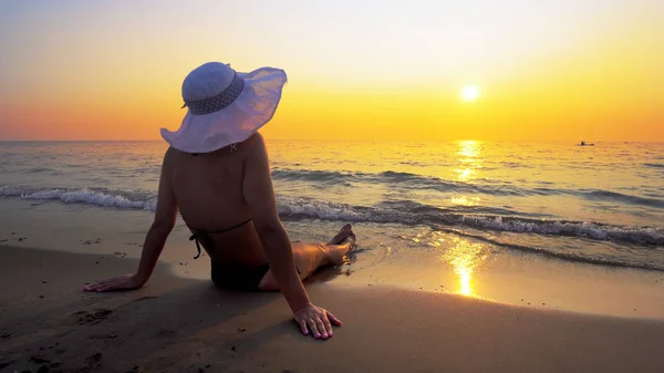 Hispanic Woman Hat Sitting Beach Sunset Sea Waves Splash Her — Stock Photo, Image