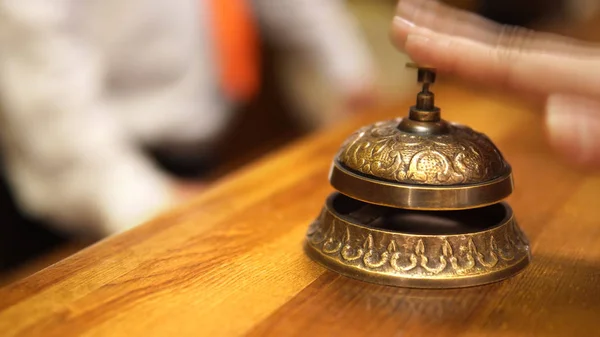 Female hand ring on hotel, restaurant bell