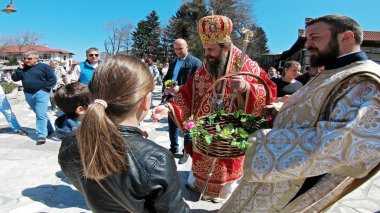 Bulgaristan 'ın Bansko kenti - 06 Nisan 2018: Bulgaristan' ın Bansko kentinde düzenlenen Paskalya geçit töreni. Rahipler ve insanlar geleneksel olarak sokaklarda yürürler, dini şarkılar söylerler ve çocuklara paskalya yumurtası verirler.